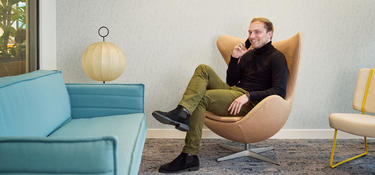 Man sitting in a chair calling on the phone